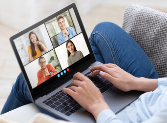 Poster - A woman sits on a couch and uses a laptop computer for a video conference. The laptop screen displays four participants in separate video frames, cropped