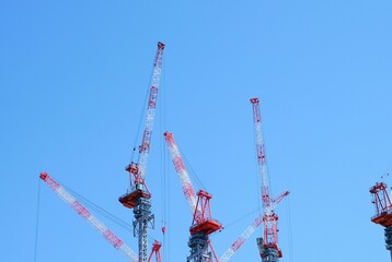 construction site with cranes against blue sky