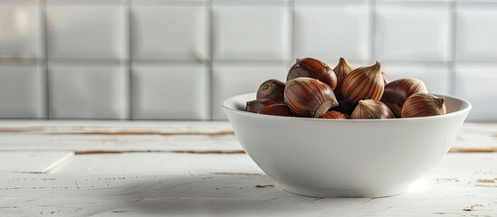 Selective focus on a bowl of freshly boiled chestnuts on a white wooden table with room for text or other elements in the image. copy space available