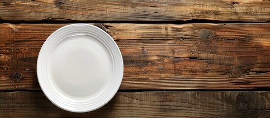 Poster - Wooden table with a white plate, showcasing a copy space image.