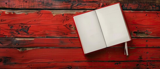 Fototapete - White book on red wooden backdrop with copy space image.