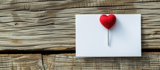 Poster - Heart-shaped paper pin attached to white note paper, creating a greeting card concept. Visualizing a note paper concept with copy space image.