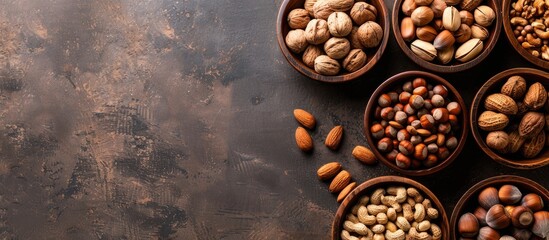Poster - Top view of different types of nuts placed in wooden bowls against a copy space image.