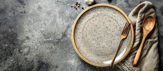 Poster - Stone gray background with vintage ceramic plate, cutlery, napkin in flatlay view offers ample copy space image.