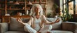 © Onchira - Concentrated mature yogi lady sitting in lotus pose on couch, keeping zen gesture, meditating with closed eyes for relaxation, mindfulness, calming down, practicing stress relief techniques