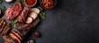 © Gular - Barbecue meat selection displayed on a dark backdrop, portraying a homemade food theme. Overhead view with copy space image.