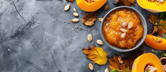 Flat lay image of a bowl with scrumptious pumpkin jam and ingredients on tile surface, with room for text in the copy space image.