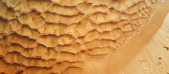 Poster - Aerial view of a sandy beach with undulating patterns. Ideal summer backdrop with plenty of copy space image.