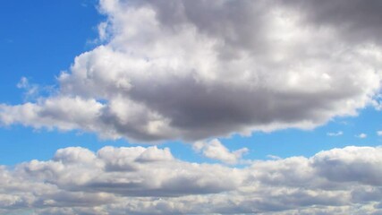 Wall Mural - Huge, low clouds slowly move across the sky. Cumulus white clouds with dark bottoms.