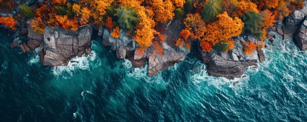 Wall Mural - Aerial view of rocky shoreline with vibrant autumn trees and blue ocean waves