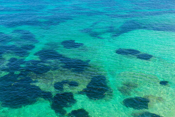 Wall Mural - Aerial view of ocean and coral reefs in southern Australia.  Water is dotted with small rocks and bubbles, creating a peaceful and serene atmosphere