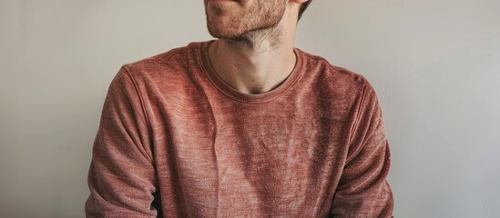 A top-view image of a relaxed man with a shirt and sweater, set against a plain background with space for text or other design elements. image with copy space