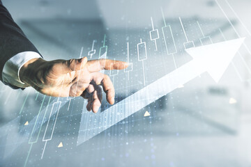 Poster - Double exposure of man hand working with abstract creative financial diagram and upward arrow on blurred office background, growth and development concept