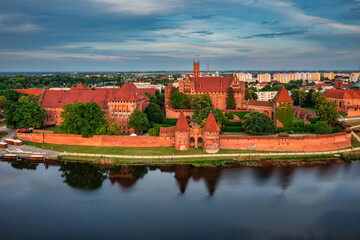 Wall Mural - Castle of theTeutonic Order in Malbork by the Nogat river at sunset.