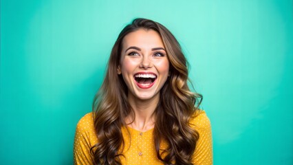 Wall Mural - Happy woman in yellow shirt laughing on turquoise background