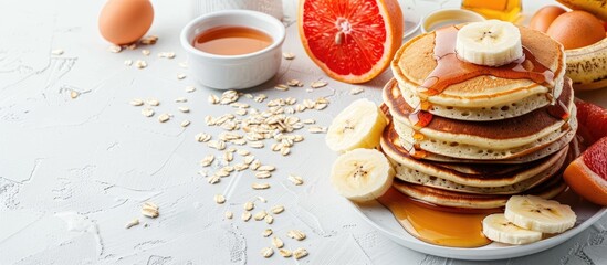 Aufkleber - Home-made pancakes piled with eggs, oats, bananas, maple syrup, and grapefruit on a white surface, with room for text, ideal for kids' meals. with copy space image. Place for adding text or design