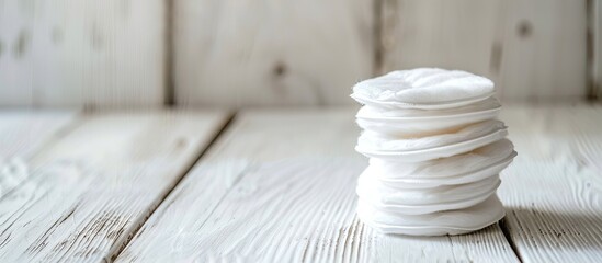 Aufkleber - A stack of cotton pads placed on a white wooden surface, providing copy space for adding text to the image.