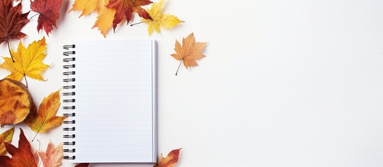 Poster - An autumn-themed composition featuring a notebook surrounded by colorful autumn leaves against a light background for a captivating copy space image.