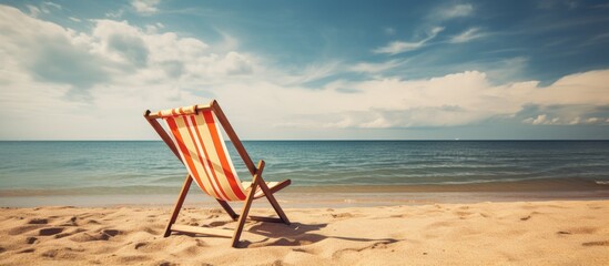 Poster - An empty, colorful wooden deckchair on a tropical beach, set against a sunny sky, in vintage retro style, as a symbol of summer vacation, suitable as a copy space image.