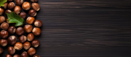 Poster - Black wooden background with hazelnuts, providing copy space image for backgrounds and textures.