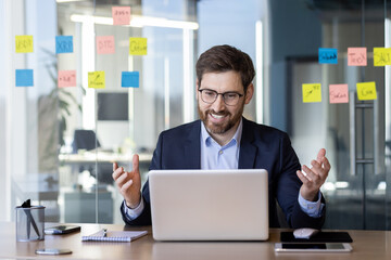 Wall Mural - Businessman in suit having video call in modern office setting, Discussing work, collaboration, technology, communication, and strategy. Professional environment and corporate meeting setup