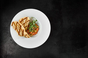 Sticker - Delicious Salmon Tartare with Avocado and Grilled Ciabatta on Dark Background Top View