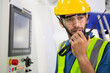 © winnievinzence - Portrait of male worker talking on radio phone or walkie-talkie with colleague to controlling work in front of industry machine at industrial factory. technology and communication at workplace
