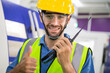 © winnievinzence - Portrait of male worker talking on radio phone or walkie-talkie with colleague to controlling work in front of industry machine at industrial factory. technology and communication at workplace