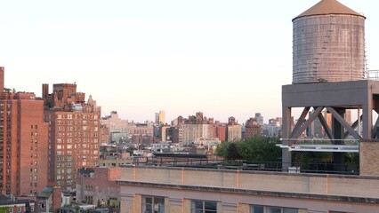 Wall Mural - New York City Manhattan skyline cityscape. Rooftop view point, residential district buildings roofs. Real Estate, urban architecture, United States streets. Midtown Chelsea district. Water tower tank.