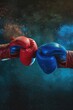 © vefimov - Two boxing gloves are shown in a close up, one red and one blue. The gloves are in the air, and the image has a mood of excitement and anticipation