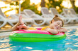 © Irina Schmidt - Happy little girl with inflatable toy ring float in swimming pool. Little preschool child learning to swim and dive in outdoor pool of hotel resort. Healthy sport activity and fun for children.