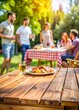 © Tekin - Empty table and blurred view of friends having barbecue party outdoors. Space for text