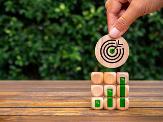 Poster - Green business, goal and growth success process for Leadership concept. Big target icon round block in hand put on cube stack with growth graph percentage on desk, leaves background with copy space.