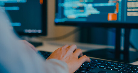 Closeup young adult Asia female freelance typing write prompt AI bot IT app program nomad, video game, terminal with coding language, designer, big data center on desktop computer in night office.