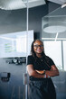 © Jacob Lund - Portrait of a black female executive standing in a professional workplace