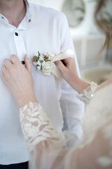 Wall Mural - The girl pins a beautiful bouquet on a man's shirt.