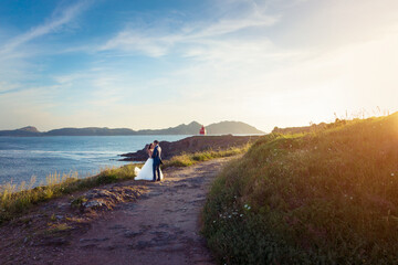 Wall Mural - Portrait of groom and bride on their way to a lighthouse