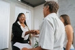 © Altura - Successful black businesswoman shaking hands with her client during meeting.