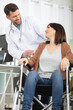 © auremar - doctor pushing wheelchair and interacting with female patient