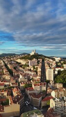 Wall Mural - Aerial view of the city of Marseille, France at sunrise. Basilique Notre-Dame de la Garde on top of hill - landscape panorama of Europe drone view. Vertical video