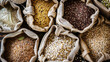© Synaptic Studio - Assorted whole grains and seeds in paper bags. Whole Grains Month, health and nutrition concept.