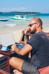 Fototapete - pensive male freelancer thinking about idea for new article recreating on ocean shore with laptop co