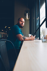 Fototapete - serious young man looking up recalling password for checking banking ablance via smartphone applicat