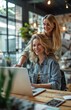© yevgeniya131988 - A young woman working on a laptop at a table, with her boss standing behind a desk