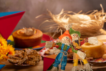 Wall Mural - Festa Junina, straw dolls in front and in the blurred background a table full of sweets from the Brazilian Festa Junina, selective focus.