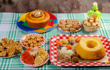 Wall Mural - Festa Junina, beautiful rustic table with dishes containing various types of sweets for Festa Junina in Brazil, selective focus.