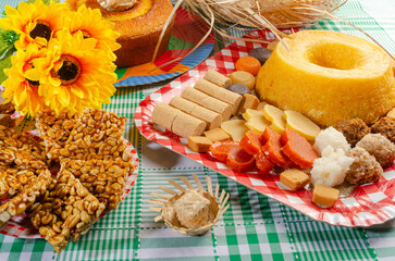 Wall Mural - Festa Junina, beautiful rustic table with dishes containing various types of sweets for Festa Junina in Brazil, selective focus.