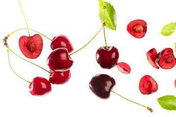 Wall Mural - Flying red sweet cherries and leaves on white background