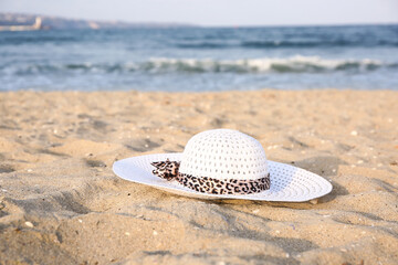 Stylish female hat on sand