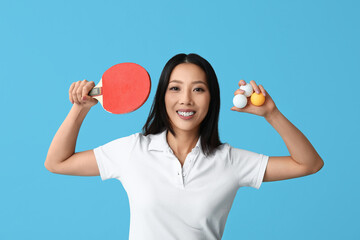 Canvas Print - Sporty young Asian woman with ping-pong racket and balls on blue background